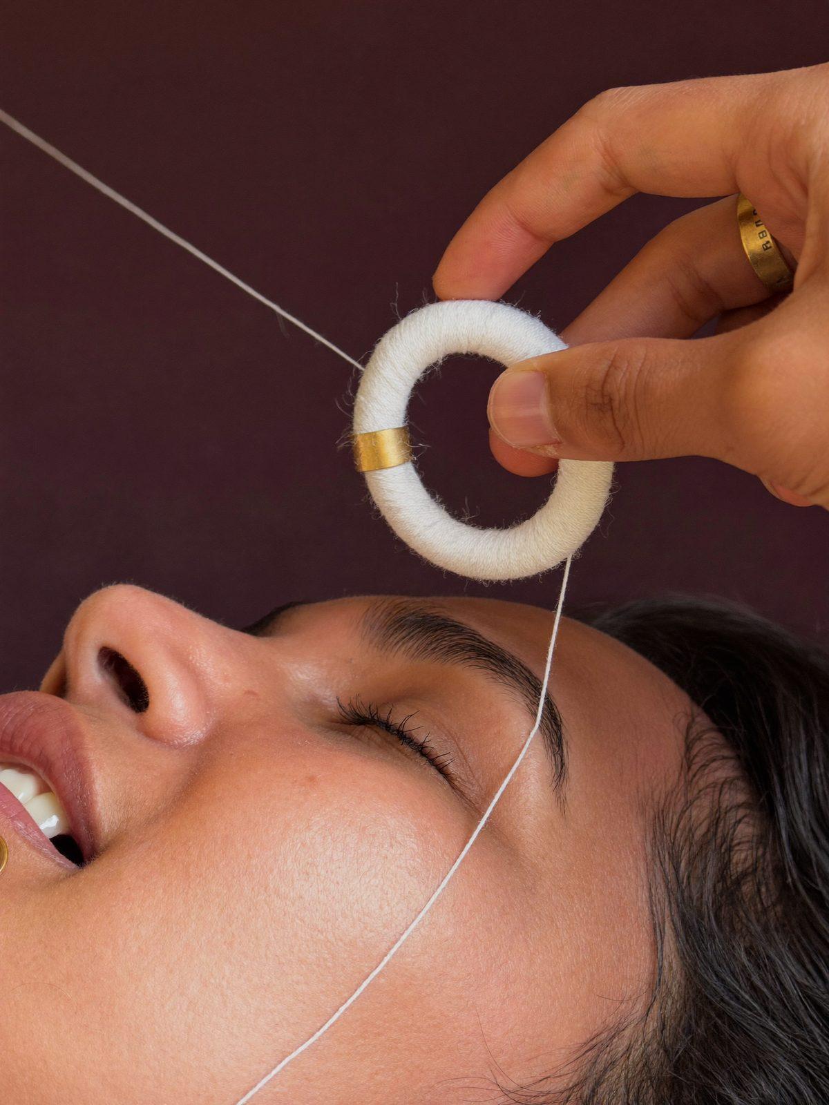 A brow being shaped with cotton thread at Chic Beauty