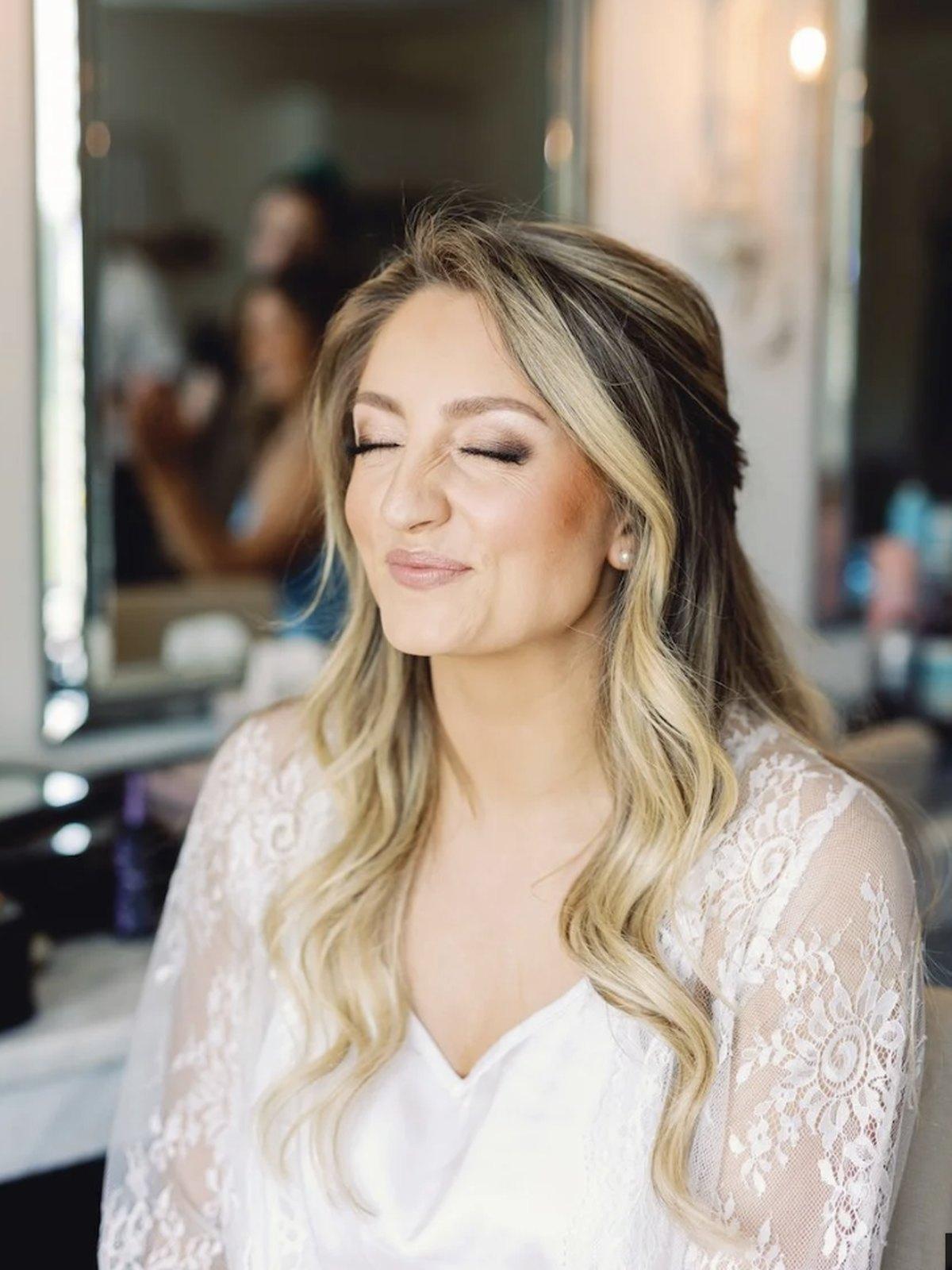 A bride in finished bridal makeup with soft waves, photographed at Chic Beauty